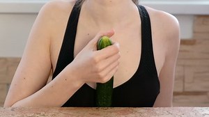 Woman hands holding cucumber and play with it. Safe sex concept.