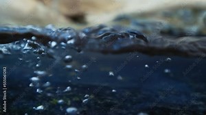 Slow motion video of water waves with splashes and falling drops. close up. split view. nature background. 4K