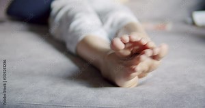 Asian woman scratching on her feet while sitting on a sofa at home .feeling itchy healthcare and medical therapy concepts.