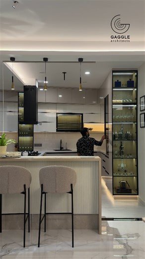 GAGGLE architects on Instagram: "The kitchen embodies contemporary luxury with a refined urban sensibility. Sleek, handle-less cabinetry in high gloss lacquer pairs seamlessly with acrylic surfaces, creating a sophisticated and clean aesthetic. A minimal island counter anchors the space, crafted from premium quartz with subtle veining that adds timeless elegance. State of the art built in appliances, including intelligent refrigeration and a flush mounted induction cooktop, contribute to a clutt