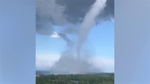 Thunder cracks as waterspout tornado churns along coast