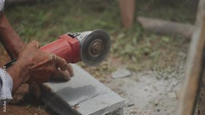 Builder skillfully operates brick cutter, using paving block cutters, shaping bricks with precision, adding finesse house construction. Creating sturdy base for home with precision and craftsmanship.