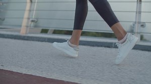 clip-1055388944-side-view-female-legs-white-sneakers-jogging