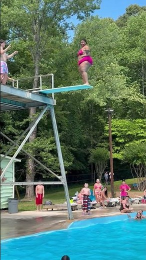 Woman makes confident dive off pool board in Hickory, North Carolina, USA