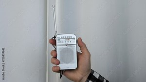 Tune in a radio station on your portable radio. Close-up of interference on the radio, turning the receiver.