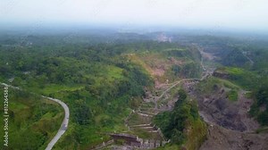 4k aerial footage of the area at the foot of Mount Merapi which consists of ravines that become lava flows, dense forests and hills that formed naturally when the mountain erupted some time ago