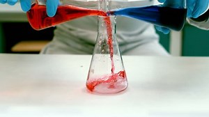 Scientist pouring liquid into a erlenmeyer flask in laboratory 4k