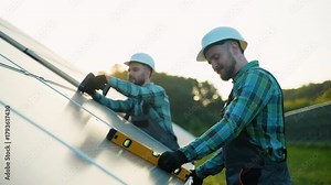 Two engineers installing solar panels with spirit level