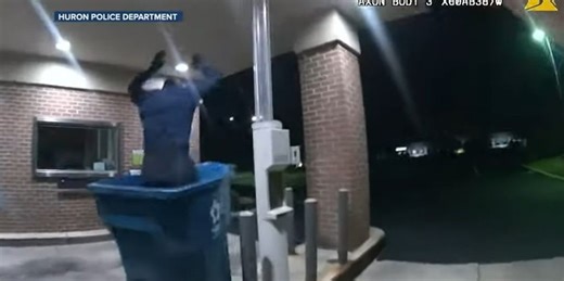 Watch: Video shows bumbling burglar fall from bank roof into trash can where cops are waiting