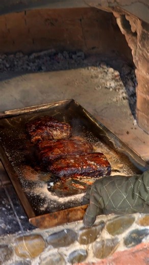 Tender meat roasting over an open flame, infusing the air with savory aromas. A timeless outdoor cooking experience. #RoastedMeat #OpenFire #OutdoorCooking #Cooking | Wilderness Grill