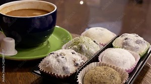 Motion of hot coffee and sticky rice cake on table with reflection background of people walking through inside coffee shop with 4k resolution