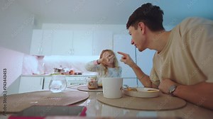 Family breakfast, dad's breakfast with daughter at home, daughter's morning breakfast with dad, girl eats with dad