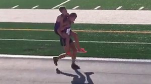 Runner sacrifices race to carry teammate
