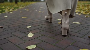 Free stock video - Woman legs in boots walking along path in autumn park
