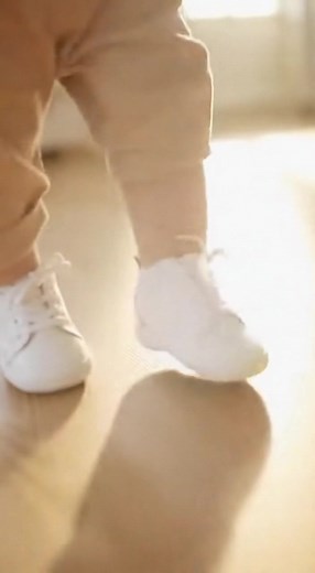 A baby discovers the magic of new shoes, taking exaggerated slow-motion steps while staring intently at their feet. The little one looks like they're learning to moonwalk for the very first time, filled with pure joy and wonder. | Jarche