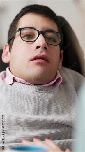 Man with a physical disability in a wheelchair engaging in a session with his speech language pathologist, focusing on oral motor exercises