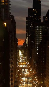 The vibrant city nightscape features illuminated windows and bustling streets filled with life