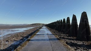 Aerial view of tranquil Cramond Island with a scenic pathway and concrete pylons at low tide, Edinburgh, United Kingdom.