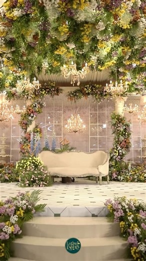 Lagna | Luxury wedding designers on Instagram: "“The venue opened like a scene from a living fairy tale. At the center, the stage drew the eye inward with its subtle depth where chandeliers floated and fountains stood quietly, adding a touch of old-world charm. On either side, the structure stretched even deeper, creating grand alcoves framed by tall opening arches that felt like doorways into another realm. Behind it all, transparent glass set neatly into square frames reflected the glow of the