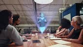Coworkers using augmented reality device to see a video call hologram...