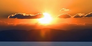 Dramatic Sunrise over Ocean and Mountains