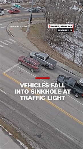 Watch the road collapse beneath two vehicles stopped at a traffic light in Omaha, Nebraska. | CNN