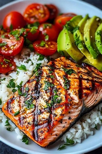 🔥 **Grilled Salmon Bowl with Avocado, Tomatoes & Rice** Juicy grilled salmon served over fluffy rice with creamy avocado and fresh cherry tomatoes — simple, nourishing, and full of flavor! **Ingredients:** • 2 salmon fillets • 1 tbsp olive oil • Salt & black pepper • 1 tsp garlic powder • 1 tsp paprika • 1 cup cooked white rice **Toppings:** • 1 ripe avocado, sliced • 1 cup cherry tomatoes, halved • 1 tbsp fresh parsley or cilantro, chopped • Lemon wedges (optional) **Instructions:** 1. Season 