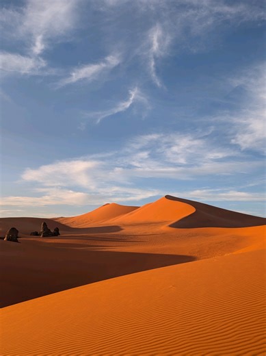 On ne te montre jamais vraiment ce que tu vis dans le désert. Pas juste des dunes. Mais des moments simples. Un Touareg qui t’apprend à préparer le thé. Des rires autour d’un jeu, assis dans le sable. Un guide qui s’arrête devant des peintures rupestres et prend le temps d’expliquer. Des voyageurs qui sourient, sans raison particulière. C’est ça, voyager dans la Tadrart Rouge, au cœur du désert algérien. Un voyage où tu ralentis. Où tu observes. Où tu vis. ✨Tu te verrais vivre ça ? #VoyageDurabl