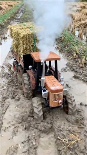 RC tractor is running in the field right after it rained.