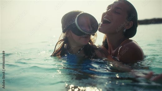 Happy mother and daughter enjoy precious family time and snorkeling at a tropical beach resort