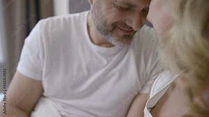 Loving man in his 50s caressing beautiful wife's hands, family relationship