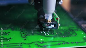 Extreme closeup showing machined production of surface-mount technology. Specific machine tool placing electric pieces onto printed circuit board. High quality 4k footage