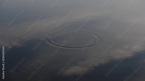 Stone falls into water. Small stones plops and produces waves and rings on calm and