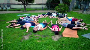 A group lesson on acroyoga master class which takes place on the lawn in the park. 4k shot
