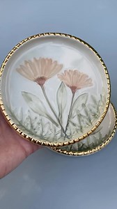 The ceramic jewelry dish here is handmade using daisies from my garden. I pressed the daisies and some various leaves into soft clay to capture the delicate and intricate botanical impressions. As you can see the real daisies are a gorgeous deep purple but sometimes I like playing with the colors and the end color of these daisies is a very soft pink. I really like the textured edge of this dish… accented with the gold, I think it does a nice job in framing the flowers. The pieces I make are all