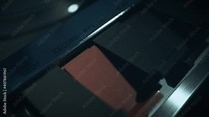 Macro shots of a 1970s quarter-inch open-reel tape recorder in operation. Shallow depth of field with focus on the rotating spools. Suggestive of a wiretap or surveillance.