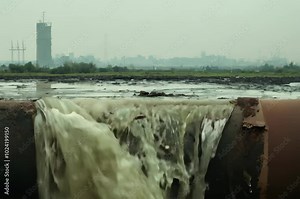 Water pollution caused by industrial waste discharge in a coastal area shows environmental impact and concerns about safety