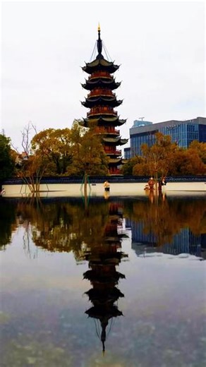 龙华塔 之水中倒影龙华塔对面是龙华会，原来建有仿古建筑，和龙华寺建筑相得益彰，后来改造升级时拆除了，结果建成一片现代感十足的商业广场，建筑风格与龙华寺格格不入，反差明显。#我用摄影看世界 #古建筑之美 #九层龙华佛塔 #南无阿弥陀佛 #龙华宝塔甲天下