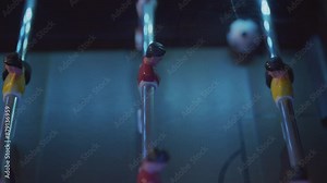 Foosball table game shot in a right to left, slow speed, close up, tracking shot.