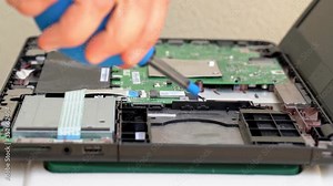 Computer technician engineer, cleans a pear, dust from a laptop motherboard. Close-up.