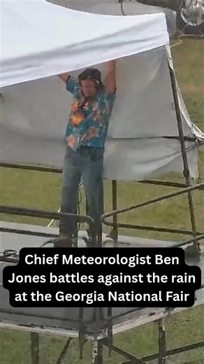 Chief Meteorologist Ben Jones battles against the rain at the Georgia National Fair