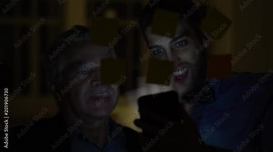 Coworkers working late building startup/ new project with sticky note paper on window