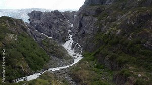 White stream falls from the snowy mountains of Alaska -aerial