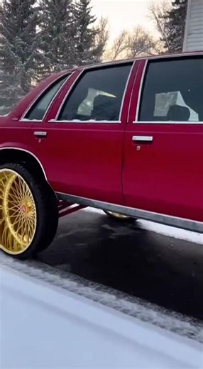 Matte red 1993 Chevy Caprice Box Chevy donk in a snowy driveway