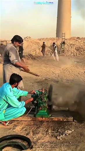 Manually Cranking a Diesel Engine: How Workers Use a Stick to Launch a Tire Rim into a Chimney