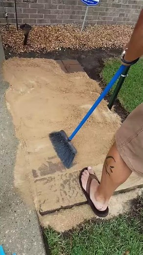 Pushing sand into patio pavers add stability and improves drainage for a stronger patio