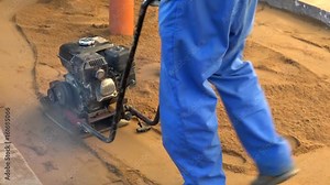 Ramming mechanism for sand. Manual compaction of earth work. The construction machine.