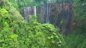 View from above, stunning aerial view of the Tumpak Sewu Waterfalls also known as Coban Sewu. Tumpak Sewu Waterfalls are a tourist attraction in East Java, Indonesia.