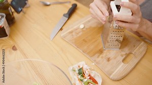 Grating Garlic on a Sturdy Box Grater, Ensuring Finely Minced Pieces for Even Flavor. Stock Video