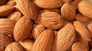 Highlighting the overall shape and size of the almond kernels. They are usually oval-shaped with a slightly pointed tip, and their size can vary from small to medium, depending on the variety. 4K